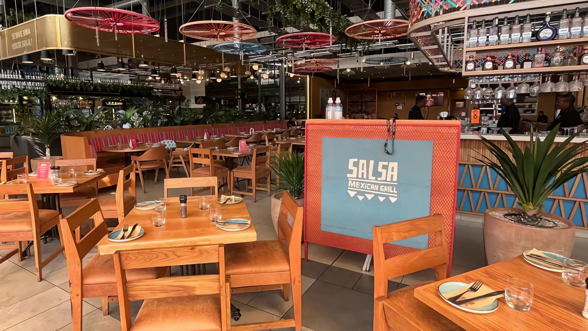 Interior view of Salsa Mexican Grill at the Design Quarter featuring wooden dining tables and vibrant restaurant decor for team building lunches