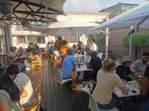 A large group of the Africa IA team seated on an outdoor patio during a team building event at The Schwarma Co.