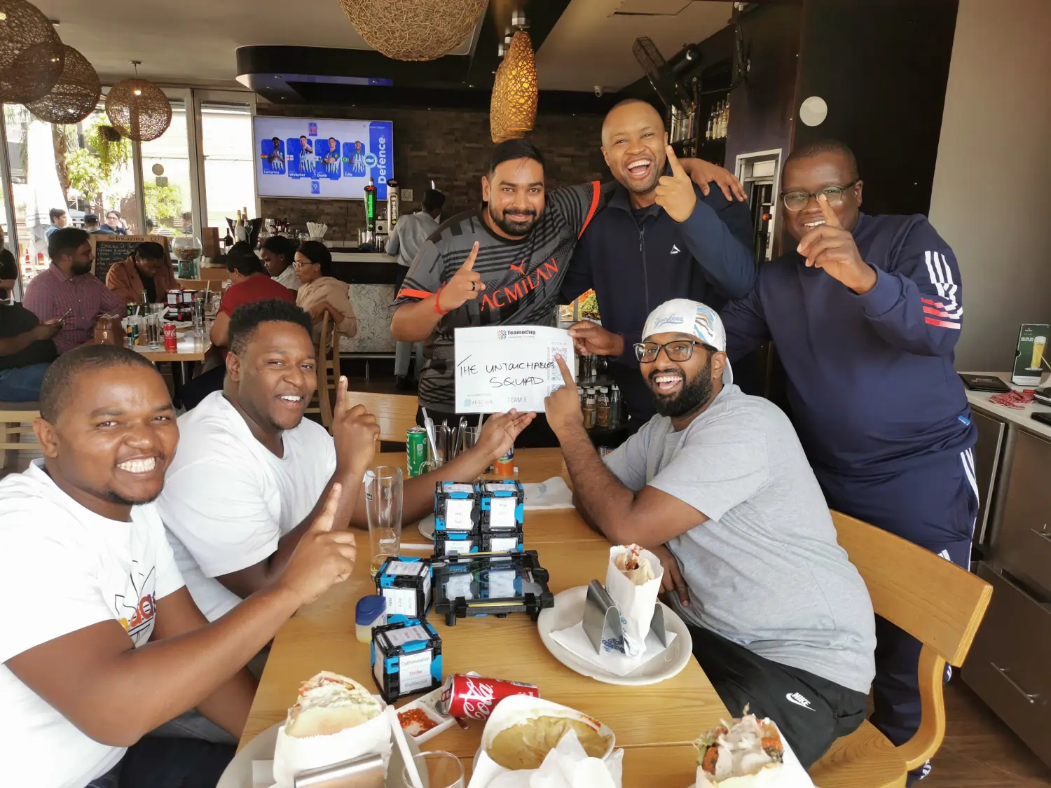 A cheerful team of men from "The Untouchable Squad" enjoying a team building event at The Schwarma Co.